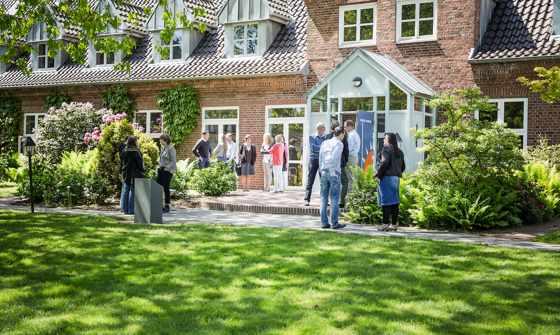 Menschen unterhalten sich vor der Nordsee Akademie.