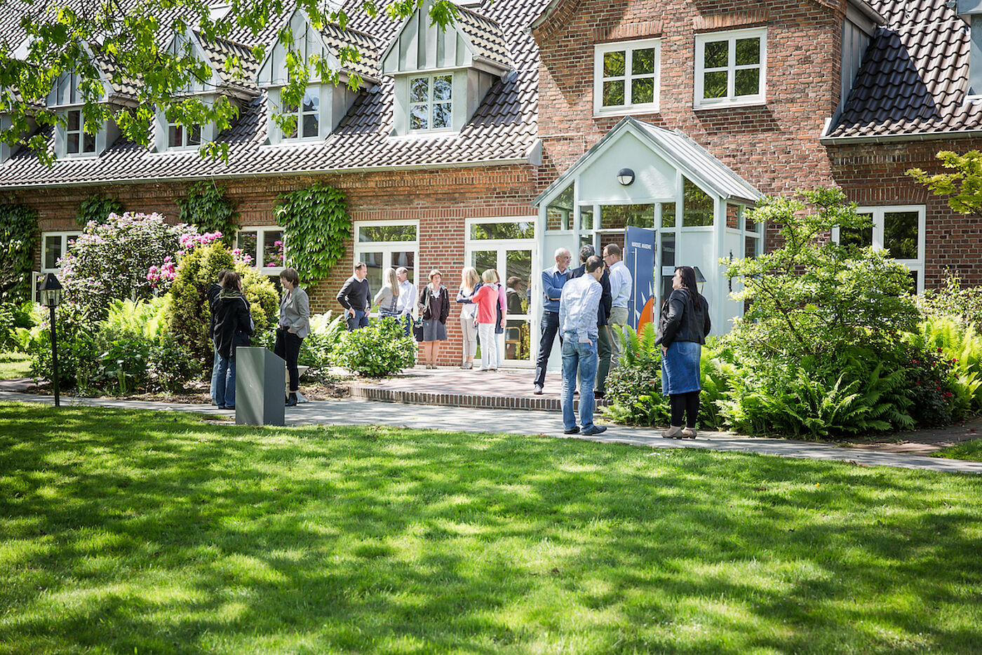 Menschen unterhalten sich vor der Nordsee Akademie.