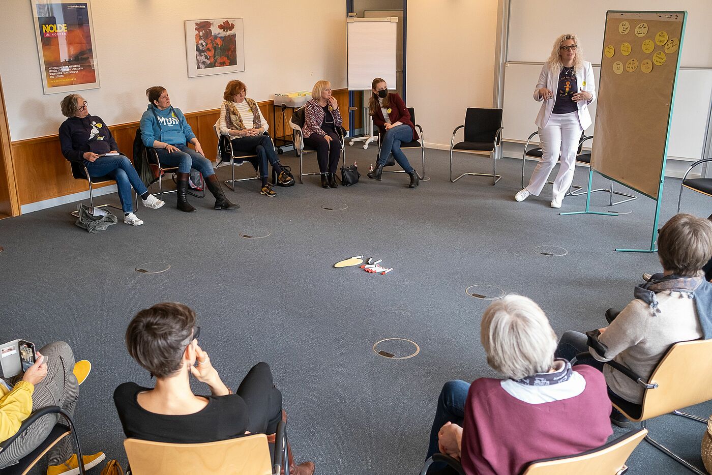 Menschen auf Stühlen hören einen Vortrag.