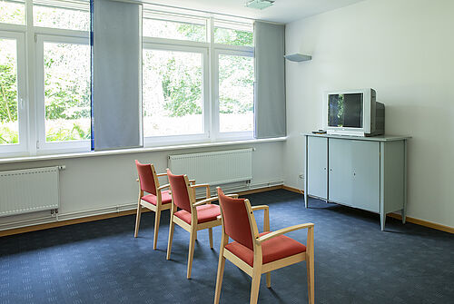 Drei Stühle und ein Fernseher im Seminarraum Hooge.