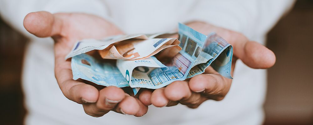 Mehrere Geldscheine in der offenen Hand
