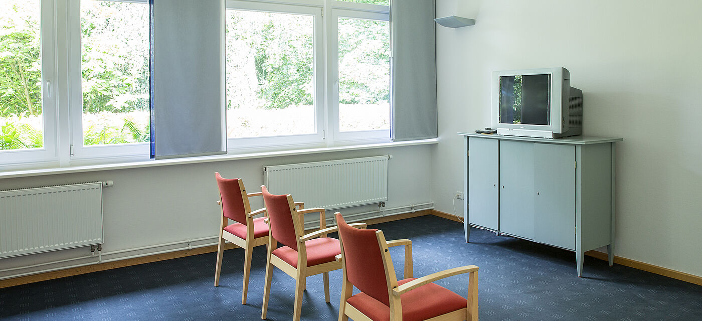 Drei Stühle und ein Fernseher im Seminarraum Hooge.